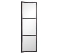 a tall mirror sitting on top of a white wall