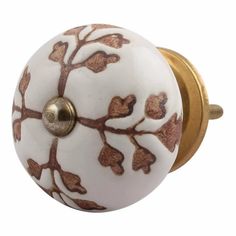 a white and gold door knob with a tree design painted on it's side