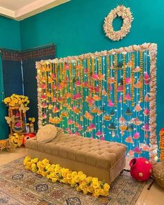 a room decorated with flowers and decorations on the wall, including a couch in front of a backdrop