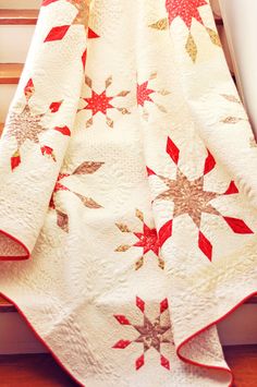 a red and white quilt sitting on top of a window sill