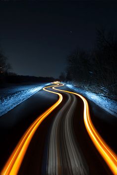 a long exposure shot of a road at night