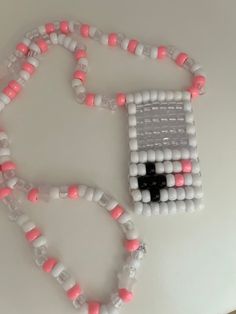 a bead necklace made to look like an object with pink and white beads on it