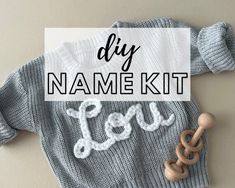 a knitted sweater with the words diy name kit on it and a wooden toy