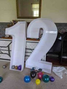 the number two is surrounded by balloons and confetti in front of a mirror