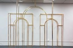 three gold metal sculptures in an empty room