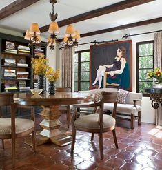 a dining room table with chairs and a painting on the wall