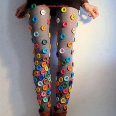 a woman standing on top of a wooden floor wearing tights with buttons all over them