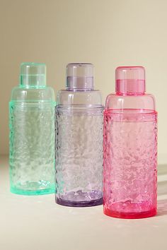 three different colored glass bottles sitting next to each other