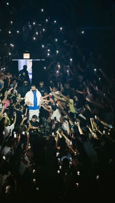 a man standing on top of a stage surrounded by people