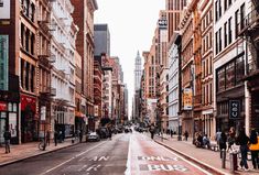 an empty city street with people walking on it