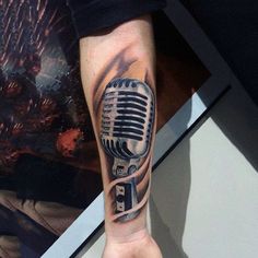 a man with a microphone tattoo on his arm