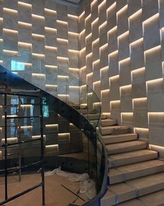 a staircase in a building that is being constructed with concrete blocks and glass balconies