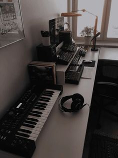 there is a keyboard and headphones on the desk