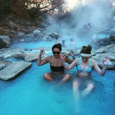 two women sitting in a hot spring pool