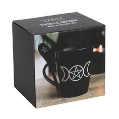 a black coffee mug with three moon symbols on the front and sides, in a gift box