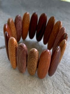 "Wooden bead bracelet, wood sample bracelet - this is a really fun piece!  The long wood beads are all different types of wood which makes it really interesting.  Each piece is polished and shows off the wood grain beautifully.  The beads are strung on elastic - I would recommend it for an average sized wrist that is about 6 1/2\" and usually wears a 7 1/2\" bracelet." Adjustable Wooden Beaded Bracelets, Brown Wooden Bracelets With Round Beads, Adjustable Wooden Bead Bracelets, Brown Wood Beaded Bracelets, Handmade Beaded Wood Bracelets In Natural Wood Color, Adjustable Natural Wood Bracelet, Adjustable Natural Wood Bracelets, Brown Stretch Bracelet With Wooden Beads, Bohemian Wooden Bead Bracelets