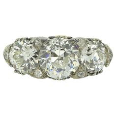 an antique three stone ring with diamonds on the sides and four stones in the middle