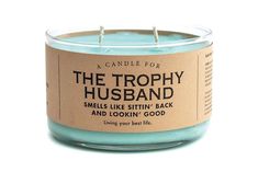 a candle that is sitting in front of a white background with the words, the trophy husband