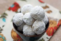 a bowl filled with powdered donuts on top of a table