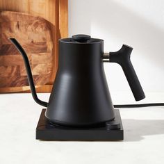 a black coffee pot sitting on top of a table