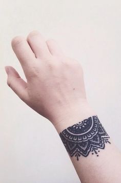 a person's hand with a tattoo on it and the wrist is holding something