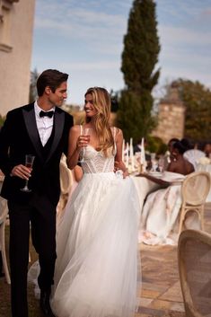 a man in a tuxedo and a woman in a wedding dress walking together