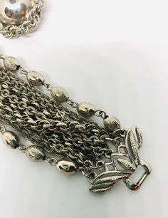 Excellent vintage 10 strand chain bracelet and earrings demi/set. Beautiful silver tone chain link brooch... 2 chains are beads in etched and smooth... plus several different chain styles make up the bracelet with ornate ends. Matching earrings with rope chain border same as in bracelet. Bracelet measures 7 1/2 inches long by just over 2 inch wide. Has secure fold over clasp. The earrings are clip backs which are secure and measure 1 1/8 inch across. All in excellent vintage condition condition Silver Multi-strand Metal Jewelry, Double Strand Silver Chain Jewelry, Silver Double Strand Jewelry, Elegant Silver Ball Chain Bracelet, Metal Double Chain Jewelry For Evening, Metal Ball Chain Bracelet, Metal Double Chain Evening Jewelry, Silver Ball Chain Bracelet, Evening Metal Jewelry With Double Chain