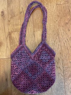 a crocheted bag sitting on top of a wooden floor