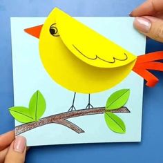 someone is holding up a card with a yellow bird on it