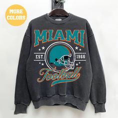 a miami dolphins sweatshirt hanging on a wall with the words,'football'written across it