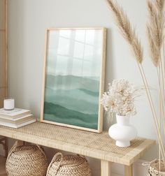 a table with baskets and vases on it next to a framed painting in the corner