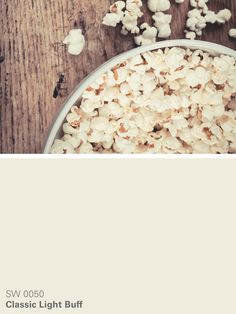 a bowl filled with popcorn sitting on top of a wooden table