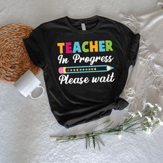 teacher in progress please wait t - shirt with coffee mug and straw hat next to it