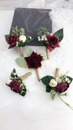 six boutonnieres with white and red flowers