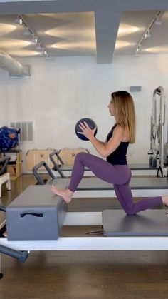 a woman is doing pivots on a treadmill while holding a frisbee