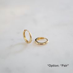 PLEASE CHECK THE MEASUREMENTS IN PERSON AS THE SIZE SHOWS VARY IN PERSON. MADE WITH LOVE IN LOS ANGELES PREMIUM QUALITY SHORT WAIT TIMES SOLID 18K GOLD REAL GOLD (WE DON'T CARRY ANY GOLD-PLATED OR FILLED JEWELRY IN OUR SHOP) Huggie Dimensions:  ● Outer diameter approximately 10 mm ● Inner diameter approximately 7 mm ● Hoop thickness 1.5 mm ●Depth thickness 1.25 mm ●Weight: 0.6 g (Pair) This piece is very delicate. Need extra care when you handle them.  Smaller size 9 mm below↓ https://www.etsy.com/listing/695287330/14k-solid-gold-huggie-earrings-dainty *FREE SHIPPING DOES NOT COME WITH ANY INSURANCE OR PROTECTION. YOU CAN PURCHASE INSURANCE ADDITIONALLY FROM THE LINK BELOW  https://www.etsy.com/listing/755295813/shipping-insurance?ref=shop_home_active_1&frs=1 Once we ship the item, we are Earrings Small Hoop, Gold Huggie Earrings, The Bling Ring, Small Gold Hoops, Tiny Hoop Earrings, Earrings Dainty, Huggie Earrings, Jewelry Earrings Hoops, Gold Hoop