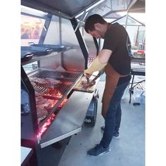 a man standing in front of an open grill