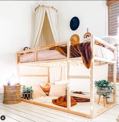 a bunk bed in the middle of a room with white walls and wooden flooring