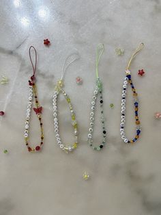 three beaded bracelets sitting on top of a marble counter next to each other