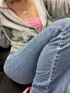 a woman sitting on top of a couch next to a cell phone in her hand