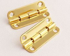 two brass plated metal hinges on white background