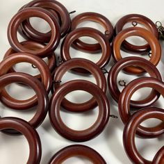 a bunch of brown wooden rings on a white surface with a chain attached to them