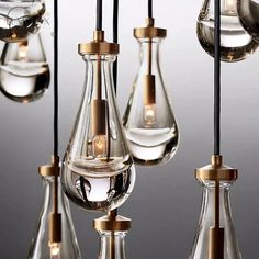 several glass vases with lights hanging from them