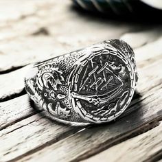 Handcrafted Silver Viking Drakkar Ship Ring - Norse-inspired Seafaring Jewelry Set sail into the world of Viking legend with our Handcrafted Silver Viking Drakkar Ship Ring, a captivating piece of Norse-inspired jewelry that encapsulates the spirit of seafaring adventure. 🚢 Meticulously handcrafted, this silver ring features an intricately detailed Viking Drakkar ship, a symbol of strength, exploration, and the indomitable spirit of the Norse warriors. The ring's design pays homage to the legendary longships that once navigated the treacherous waters, making it a powerful and symbolic accessory. ⚔️ Channel the bravery and resilience of the Vikings with this unique Drakkar Ship Ring. The exquisite silver craftsmanship brings to life the grandeur of these legendary vessels, making it a stat Handmade Bohemian Engraved Round Ring, Handmade Unique Engraved Round Ring, Symbolic Engraved Skull Ring For Gift, Handmade Symbolic Skull Ring For Gift, Symbolic Engraved Skull Ring Gift, Symbolic Handmade Skull Ring Gift, Handmade Symbolic Skull Ring As Gift, Handmade Bohemian Skull Ring As Gift, Handmade Bohemian Skull Ring For Gift