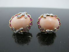 "Fun and lovely vintage omega back post earrings. Large natural pink coral in oval cabochon shape measures 15.0mm x 12.0mm x 5.0mm, accented by a halo of natural pink sapphires, each measuring 2.1mm x 1.3mm. Round brilliant cut diamonds form a leaf design at each side.  Each earring measures .75\" x .5\". Total weight of 16.4 grams. Hallmarks at each back. 10650-2" Formal Coral Oval Jewelry, Pink Oval Hallmarked Earrings, Gold Chunky Earrings, Chunky Earrings, Vintage Omega, Earrings Large, Pink Coral, Oval Cabochon, Round Brilliant Cut Diamond