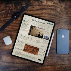 an ipad, mouse and cell phone sitting on a wooden table next to each other