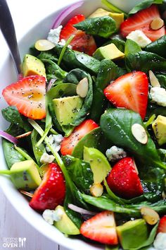 a salad with strawberries, avocado and spinach in it is featured on the facebook page