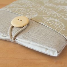 a wooden button sitting on top of a cloth covered case with fabric backing and buttons