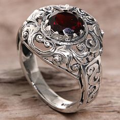 Designed and crafted by Indonesian artisan Agung Jagra this ring features a 2.5 carat garnet. Sterling silver leaf and swirl designs outline the faceted stone and twist down the side of the ring's band. Garnet Rings With Intricate Design, Garnet Sterling Silver Ring, Fashion Skirts, Garnet Ring, Wide Band Rings, Filigree Ring, Silver Rings Handmade, Silver Filigree, Jewelry Packaging