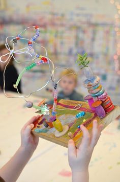 a young child holding up a toy with beads on it